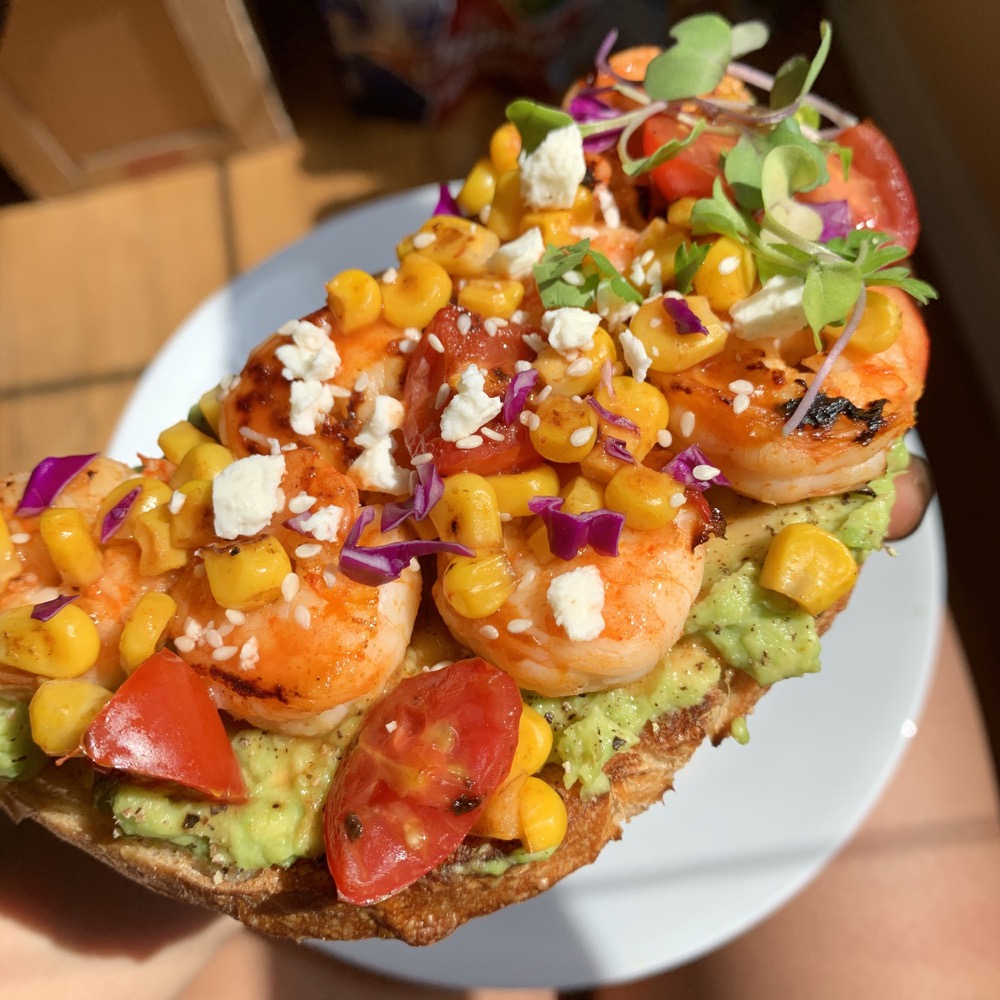 shrimp avocado toast topped with corn and feta