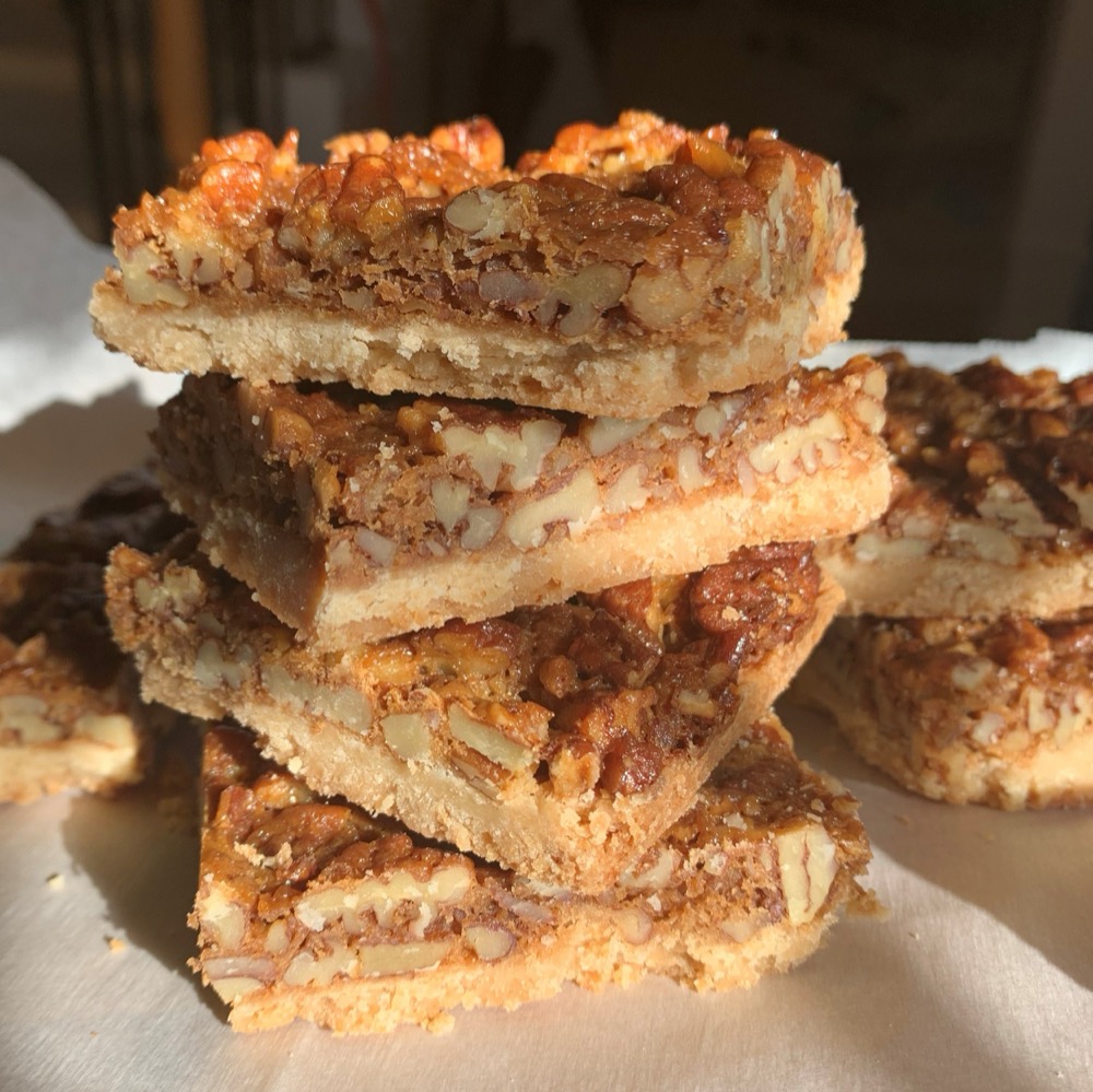 stacked pecan bars on shortbread crust