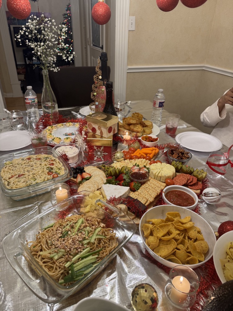 holiday potluck spread with noodles, cheese board, and chips