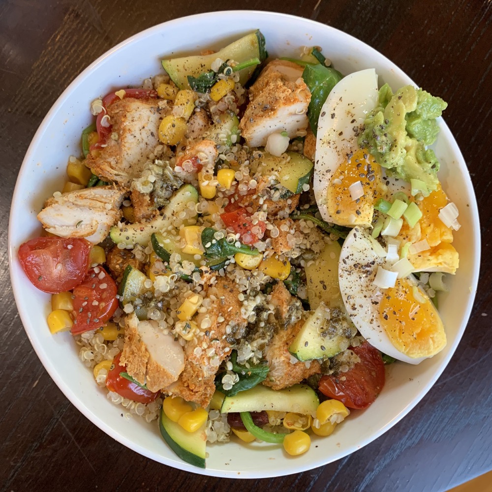 quinoa bowl with chicken, jammy eggs, corn, and avocado