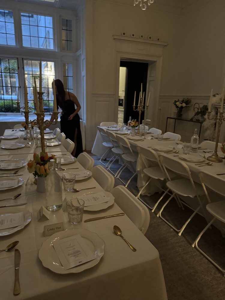 white dinner tables with gold candelabras and place cards