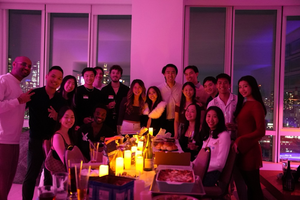 group photo at a candlelit dinner party with city views